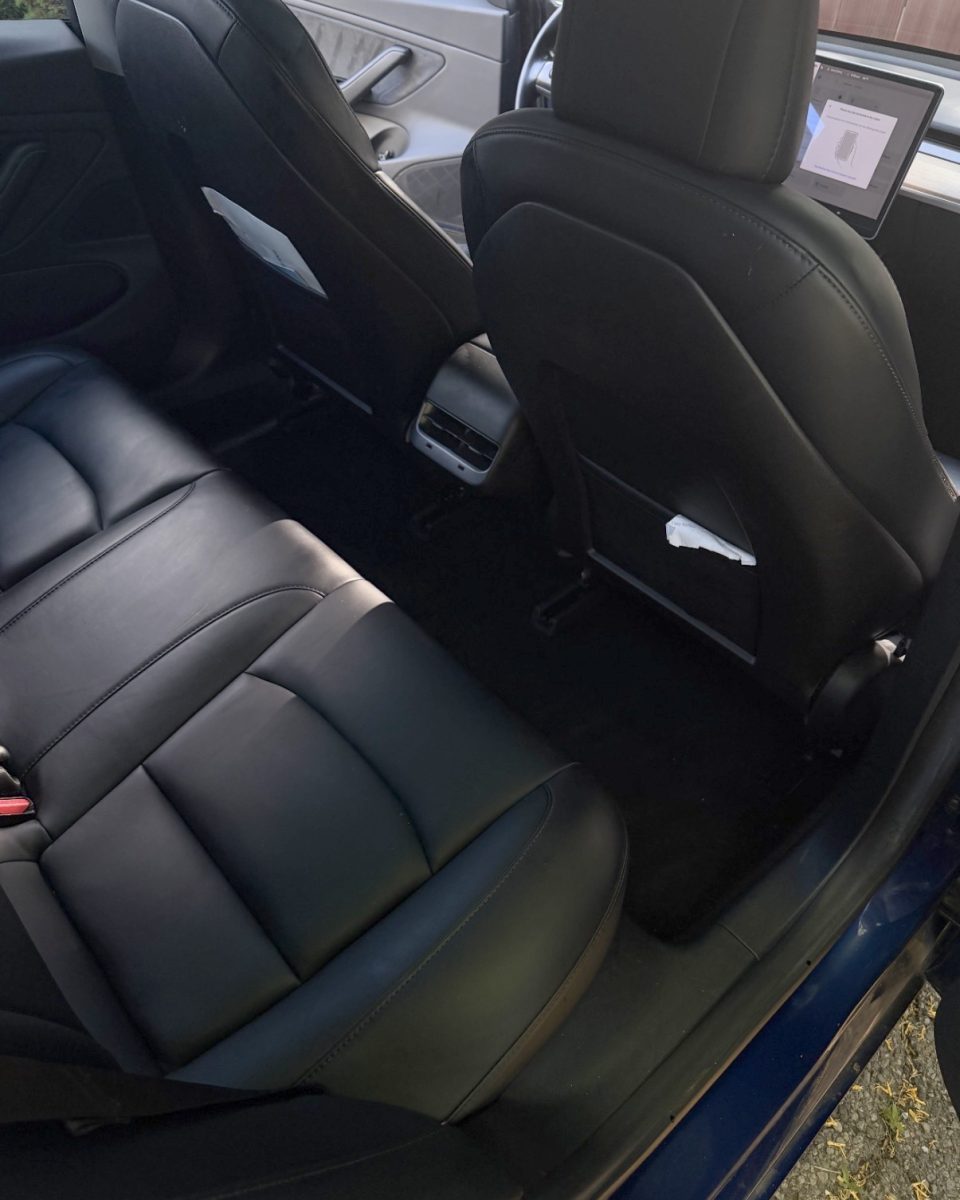 Same Tesla Model 3 rear seat and floor after detailing, clean black leather and carpet