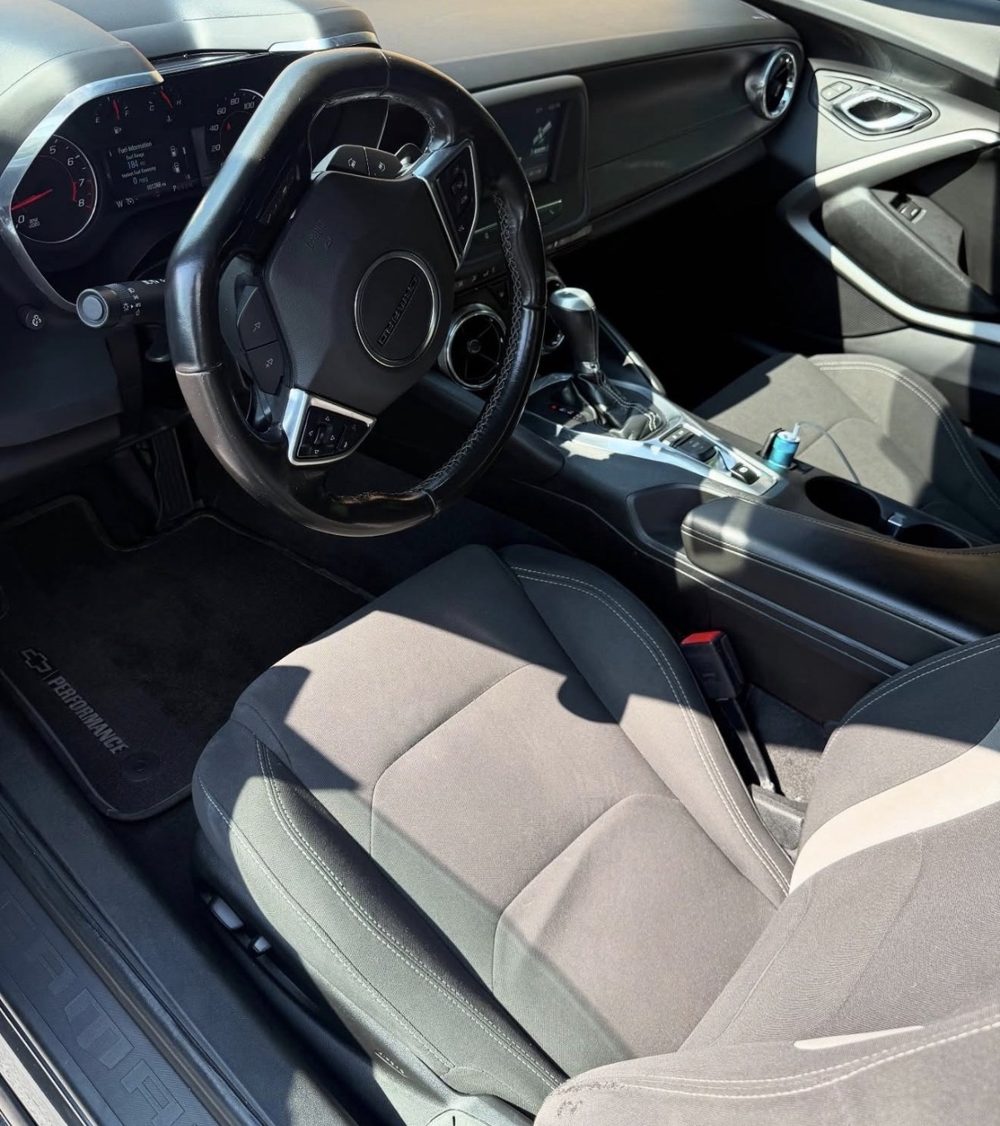 Same Chevrolet Camaro driver side after detailing, clean seat and floor mat